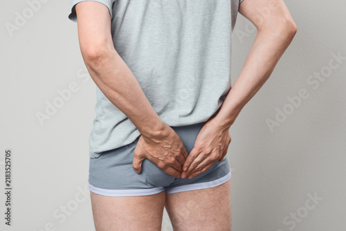 Fotografie Rear view of man experiencing anal fissure discomfort and proctological pain