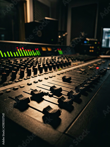 Professional audio mixing console with faders and controls in studio setting, creating music