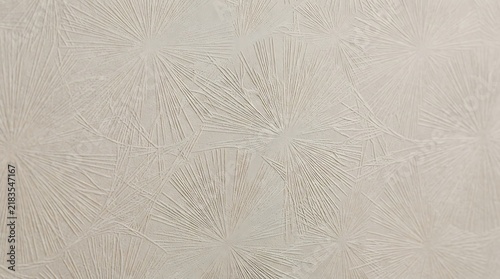 Textured plaster wall with radiating starburst pattern neutral beige background