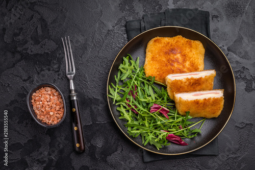 Foto Chicken cordon bleu cutlet with cheese and ham on plate with salad