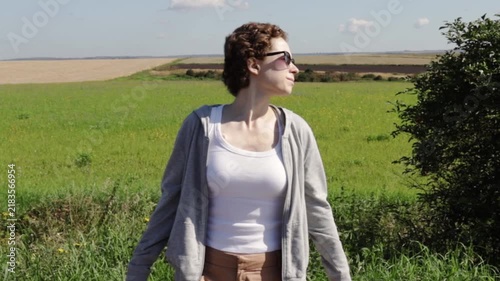 authentic cancer survivor enjoying a quiet moment in the countryside, representing emotional resilience, ordinary life and connection with nature during treatment