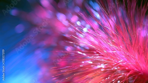 Close-up of glowing, feathery strands in vibrant pink and blue hues