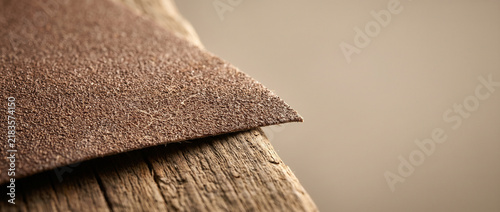 Sandpaper sheet resting on wooden surface in soft light  