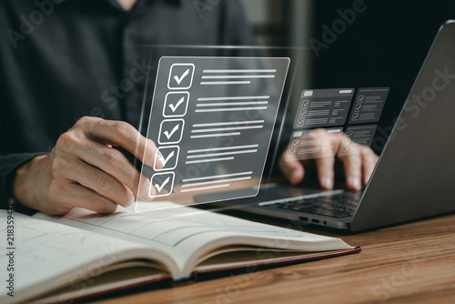 Business person filling out online checklist form with digital interface on laptop.