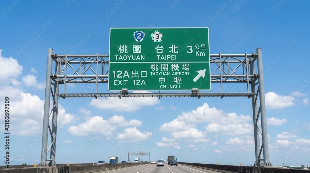 Fototapeta premium Highway Overhead Signage Directing Travelers Towards Taoyuan Taipei and Airport Destinations
