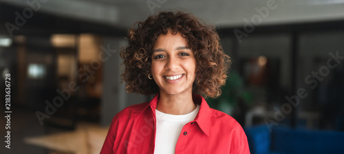 Konstfotografi Close up headshot portrait of smiling young hispanic woman with curly hair, casual style in office