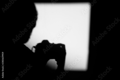 Close up black and white shadow of man taking selfie portrait on the dirty wall