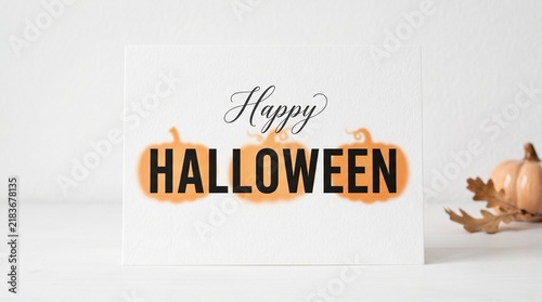 Happy Halloween typography greeting card design with orange pumpkin illustrations.
