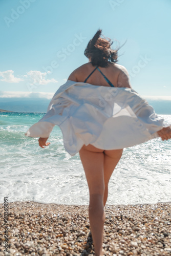 Woman in swimsuit walking on Croatia beach