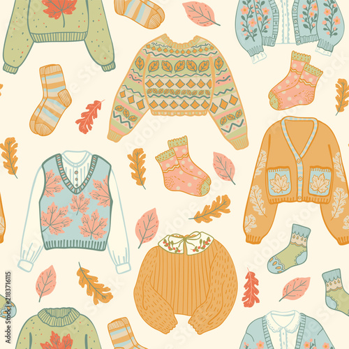Autumn knitwear seamless pattern. Cartoon fall clothes. Sweaters and socks. Autumn leaves vector. Off white background.