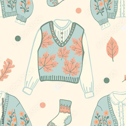 Cartoon seamless pattern with blue knit vest, shirt, and floral cardigan. Vector design on off white spotted background.