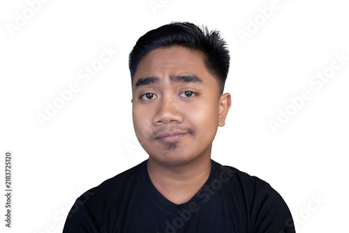 Fotografie Doubtful Indonesian man wearing a black t-shirt looking forward with a skeptical and uncertain expression against a white background