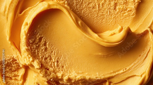 Macro shot of rich orange mango gelato with smooth creamy swirls. Ideal background for summer dessert menus or food concepts.