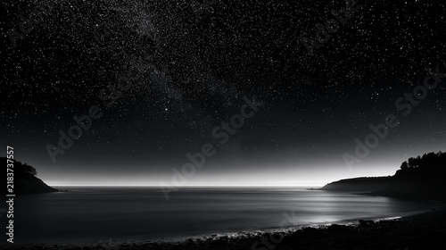 Plakat 満天の星と天の川が広がる静かな海岸を映した幻想的なモノクロ夜景