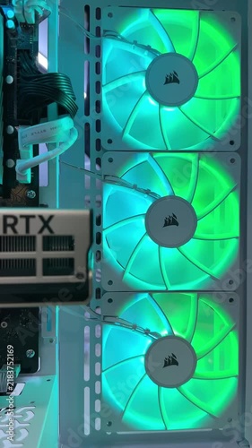 Close-up of a white desktop PC interior featuring three stacked Corsair RGB cooling fans beside an RTX graphics card and visible cable management modern gaming PC hardware and airflow concept
