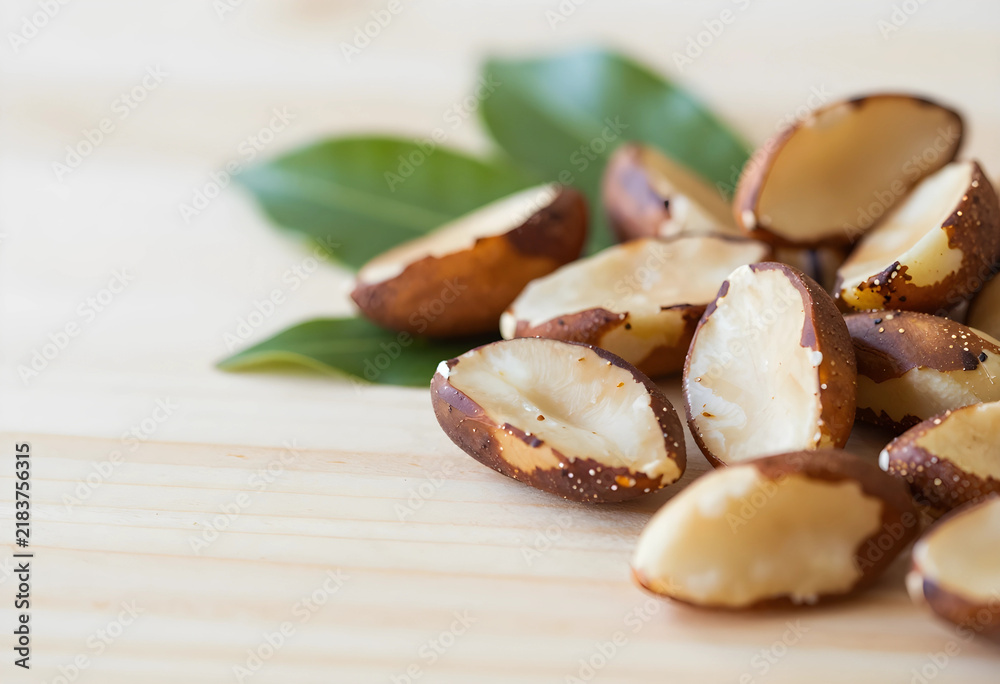 Obraz premium Healthy nutrition and superfood, organic brazil nuts with green leaves on a wooden table for vegan diet and natural plant based protein source snacks