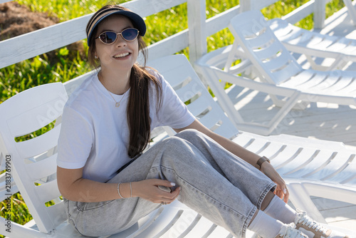 Smiling Young Woman Relaxing on Lounge Chair at Summer Resort