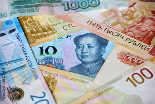 Chinese yuan banknote surrounded by russian rubles. Concept of economic cooperation between the China  and Russia, trading and support