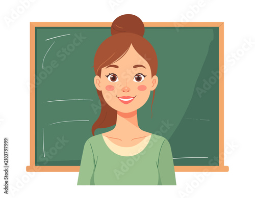 A young woman teacher with glasses is standing near the classroom blackboard