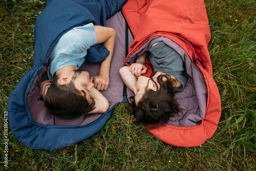 young couple in sleeping bags for nature and hiking