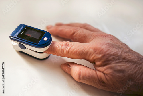 Fotografie Close-up of a human hand using a pulse oximeter device to measure blood oxygen l