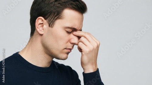 Frustrated Young Man Rubbing His Forehead in Stress