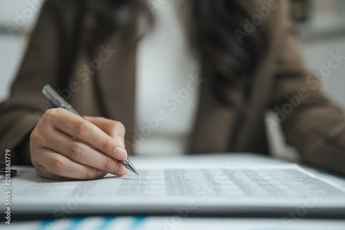 Audit notes guide auditing as an auditor checks budgeting in a business background of rows, the silver pen adding audit notes for auditing as the auditor checks budgeting in this business background.