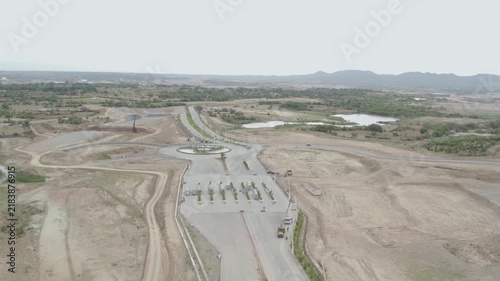 Elevated view of a major road development project in Punjab, Pakistan, showing newly built roads, a roundabout, earthworks and surrounding undeveloped terrain