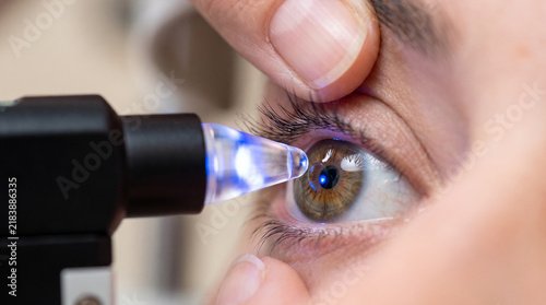 Close-up of eye examination using blue light slit lamp instrument for ophthalmology and glaucoma pressure testing