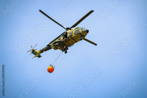 Firefighting helicopter carrying a water tank