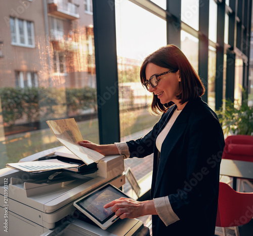 Businesswoman scanning documents on an office printer