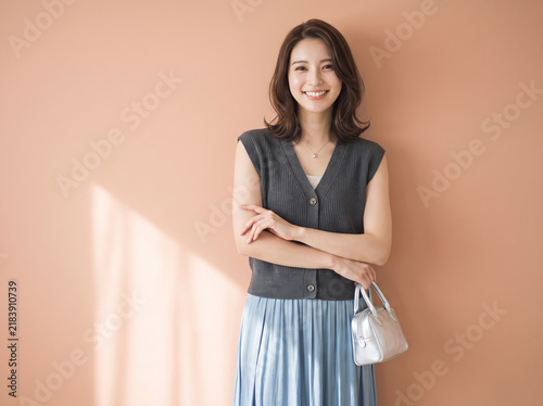 Plakat 腕を組んで優しい笑顔を向けるきれいめスタイルの女性