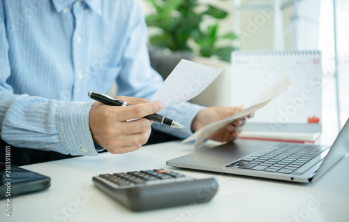Cuadro en lienzo Business professional reviewing financial documents with pen laptop and calculator for accounting expense tracking budget control tax planning invoice verification and cash flow management