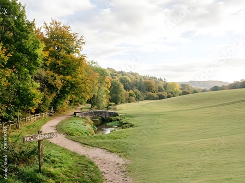 Scenic countryside landscape featuring a winding dirt path, a small stone bridge over a stream, and a wooden signpost reading New Beginnings against autumn trees and green hills.