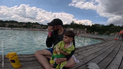 Mother with child wrapped in towel by pool