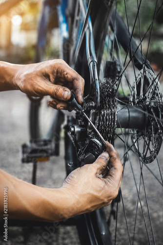 Bicycle Maintenance: A close-up shot captures a mechanic's hands skillfully working on the gears of a bicycle.