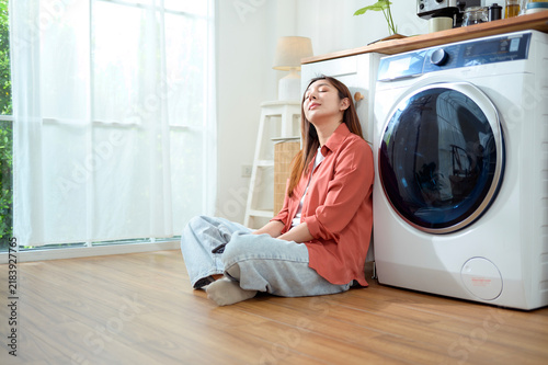 Woman Sitting Beside Washing Machine in Bright Laundry Room