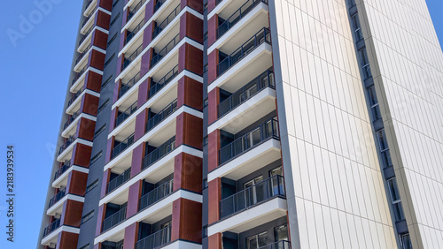 Quadro su tela Modern high rise residential building facade with numerous balconies under a cle