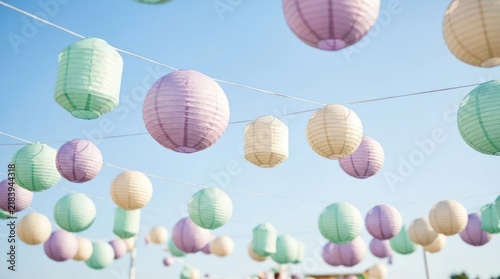 Colorful paper lanterns hanging against a blue sky.