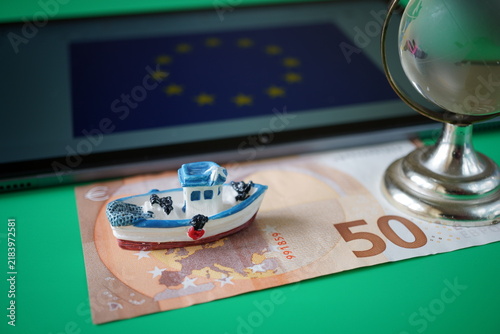 A euro banknote with a boat and the flag of the European Union. Finance and economics.