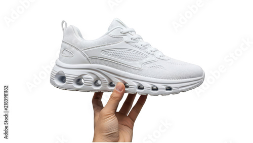 A hand holding a modern white sneaker shoe for running and fitness activity