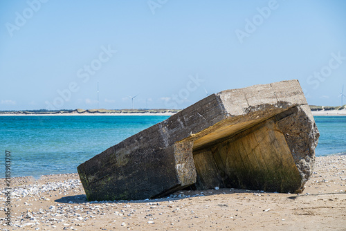 Fotografie Abandoned concrete military bunkers eroding into the sea on a sandy beach in Vigso Denmark