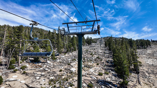 A Ski Lift looking at the top of the mountain with transport cable seats and support in the Summer os tuorists can go to the top of the mountain