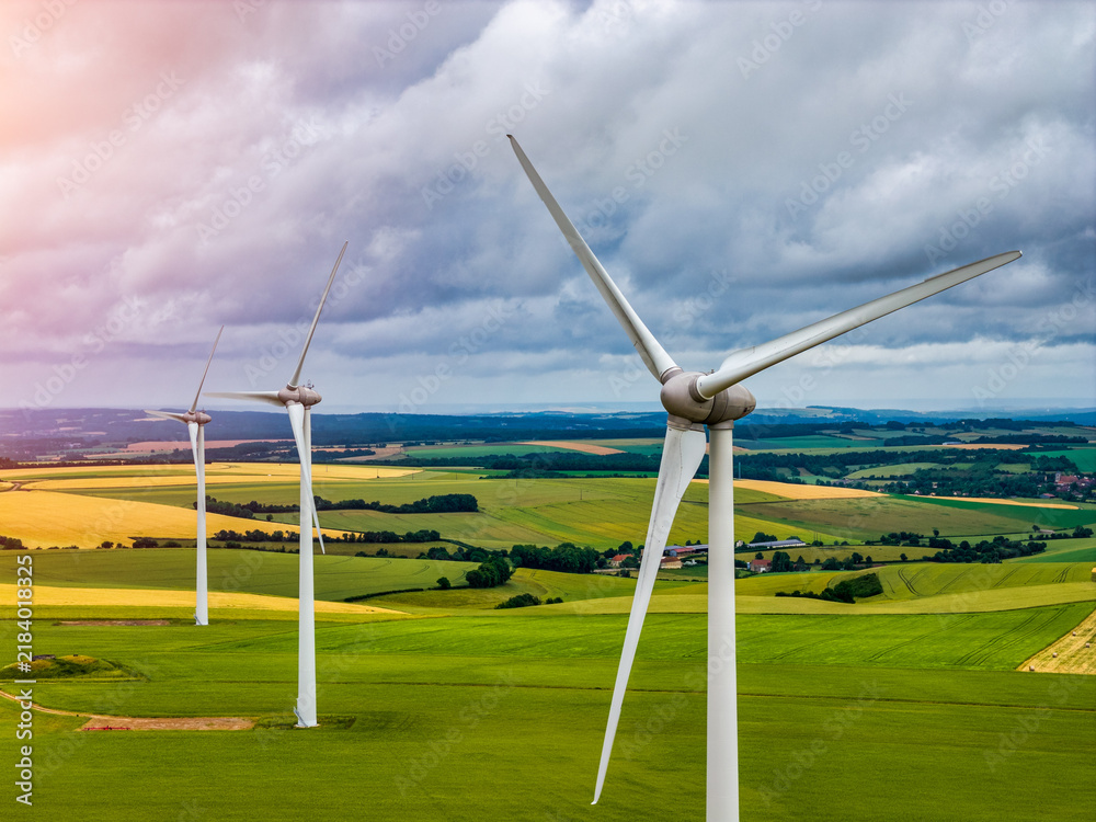 Obraz premium Wind turbines generating renewable green energy and electricity in an open landscape, modern power technology infrastructure for sustainable energy production and clean environmental power systems