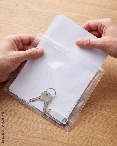 Hands packing emergency documents into waterproof pouch