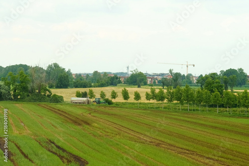 Tractor working on lush green fields in a peaceful rural landscape
