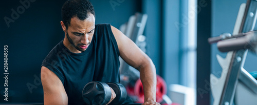 Принти на полотні Focused Male Athlete Training In Gym With Dumbbell, Engaged In Workout, Exercising, Strengthening, Building Muscle, With Equipment