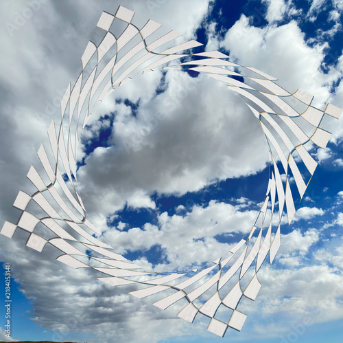 Abstract pattern of squares  with checkerboard effect in playful trailing design centers around opening showing the blue sky with white clouds as background.