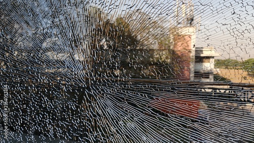 Obraz na płótnie Dramatic close up of shattered glass with extensive radial cracks over a blurred