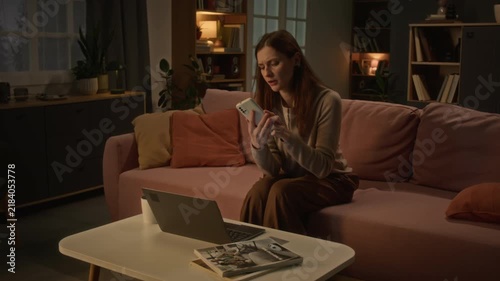 Worried Caucasian young woman using laptop, answering phone call and holding credit card. Ideal for online banking security, financial fraud prevention campaigns and customer support ads